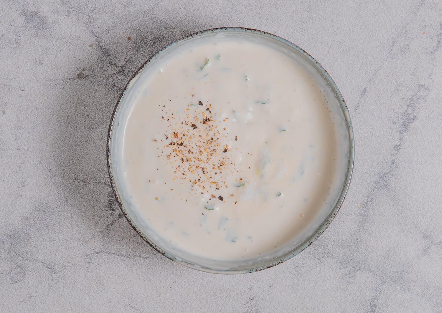 Creamy lemon garlic dipping sauce mixed with parsley and seasoned with pepper for baked avocado fries